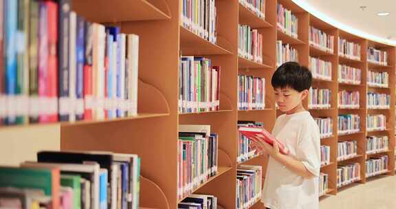 中国小男孩在图书馆搜寻书籍