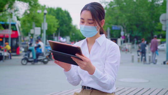 青年女人戴着口罩使用平板电脑视频素材模板下载