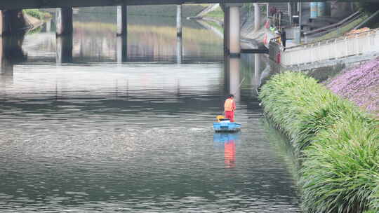 河道清理工撑船清理河面