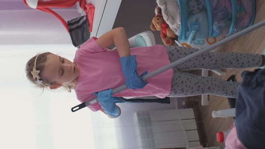 小女孩用扫帚清洁地板