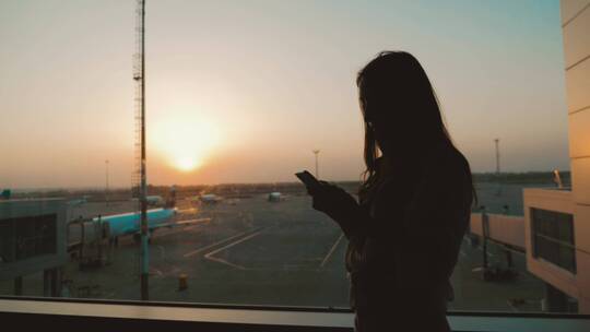 女孩在机场欣赏黄昏美景