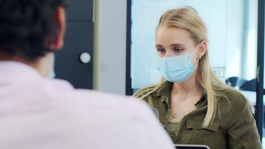 戴口罩的女人在翻阅笔记本