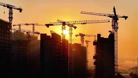 夕阳下建筑工地塔吊剪影