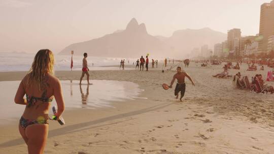 人们在海滩上玩桨球视频素材模板下载