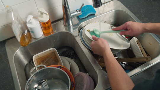 一个人在水槽边洗碗