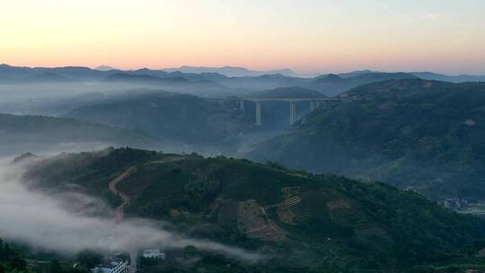 航拍清晨远山群山晨雾缭绕高架桥灯火点点