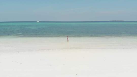 空中慢动作：女人走在白色沙滩热带海滩绿松石水c