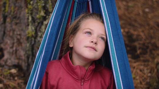 女孩躺在吊床上欣赏着自然风光视频素材模板下载