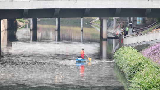 河道清理工撑船清理河面