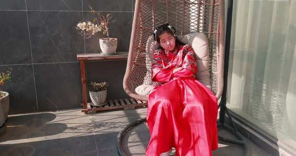 穿汉服女孩坐吊椅休憩