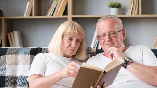 老年夫妇在沙发一起看书
