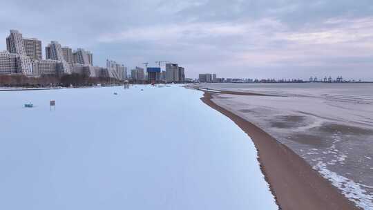 沿海城市雪后沙滩边的高楼景象