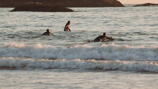日落时冲浪者在海上冲浪
