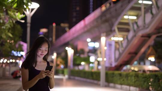 女孩夜晚在路边玩手机等人视频素材视频素材模板下载