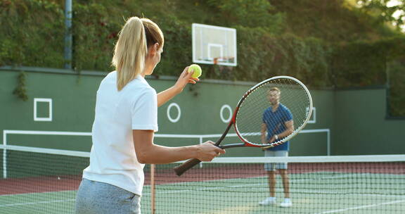 户外球场打网球的夫妇