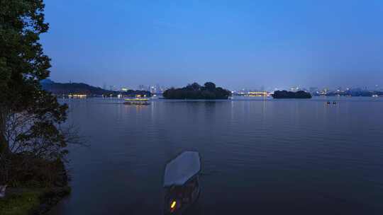 中国杭州 夜色下的西湖夜景延时 摇橹船驶回