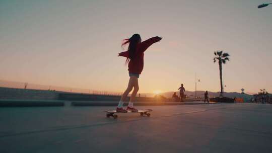 夕阳西下女孩在路边滑滑板