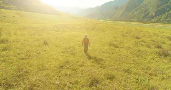 飞越背包徒步旅行游客在夏季穿越绿色山地巨