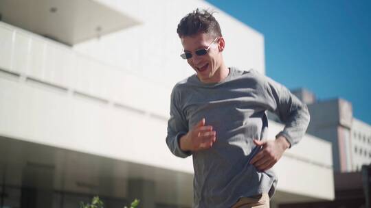 男人沿城市街道微笑奔跑视频素材模板下载