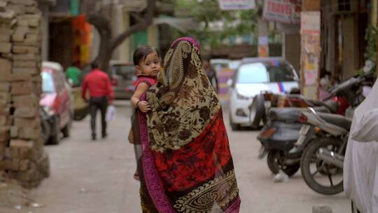 女人抱着孩子走在街头
