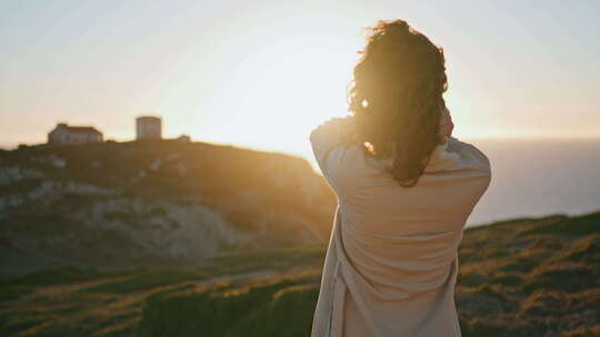 体贴的女人在大洋山上看日落
