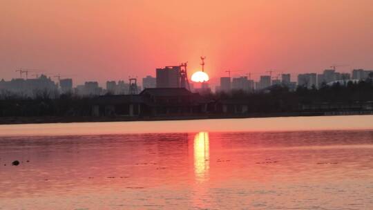 城市的黄昏，落山的太阳映红了整个湖面