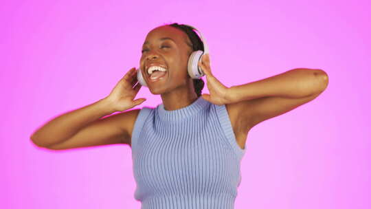 黑人妇女，跳舞和耳机听音乐庆祝胜利