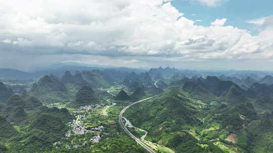 蓝天白云下桂林喀斯特山峰间穿行的高速公路