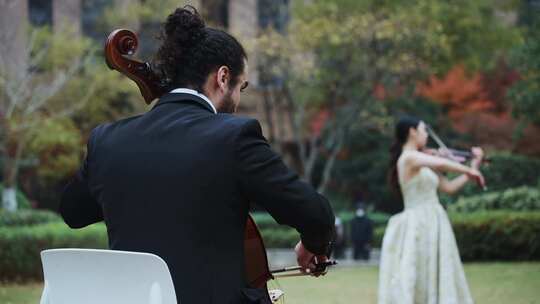 美女小提琴和外国人大提琴草坪演奏视频素材模板下载