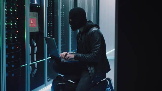 黑客在服务器室操作电脑