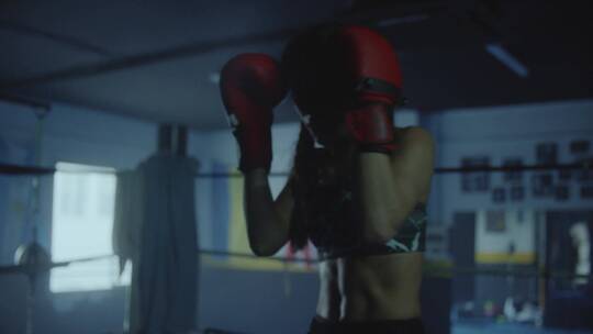 夜晚女人在拳击场锻炼