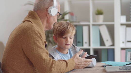 老人在和孙子玩手机视频素材模板下载