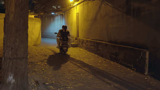 夜晚巷子里路过的摩托车