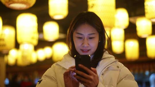 女性冬天穿羽绒服传统历史古镇景点使用手机