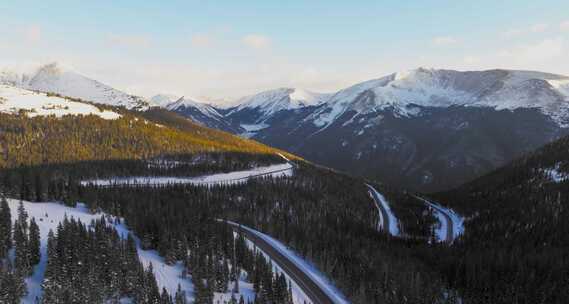 汽车行驶在森林公路上盘山路旅行自驾游雪山