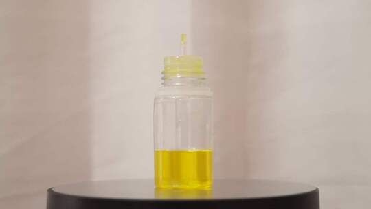黄色小液体填充瓶在白色背景上旋转