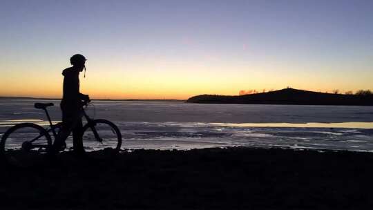日落时分骑自行车的男孩剪影