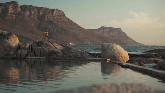 4K - 海边岩石上练习瑜伽的女人01视频素材模板下载