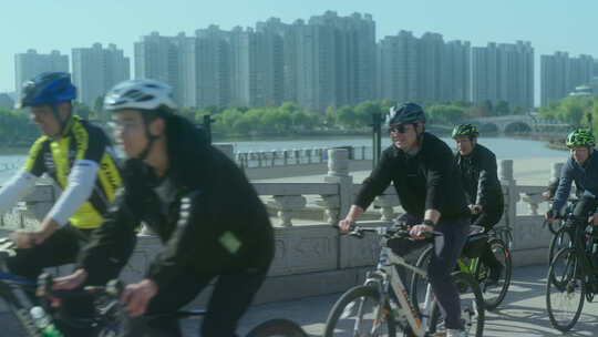周末公园拱桥上骑自行车休闲的人