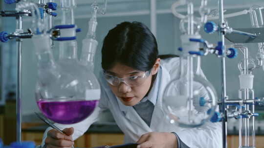中国年轻女性在实验室观察玻璃蒸馏中的化学