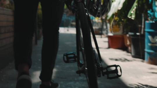 一个城市骑自行车的人骑着他的自行车走路_