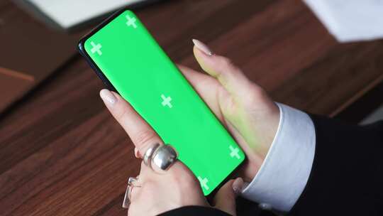 女性使用绿色背景智能手机在手机上滚动手部视频素材模板下载
