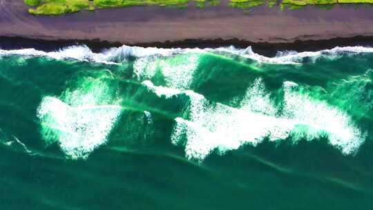 翠绿色的海浪拍打着海岸