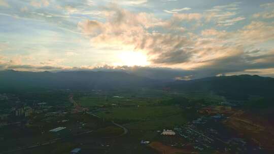 航拍夕阳时分的山脉天空云彩和城镇