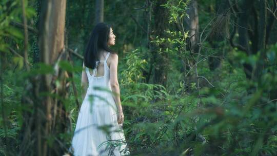 穿白色长裙的女孩在森林行走的背影视频