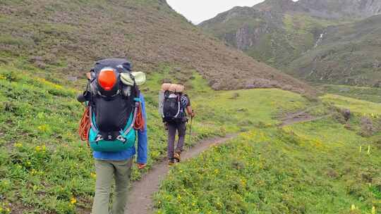 川西格聂山区阿沙沟草原花海的徒步旅行者