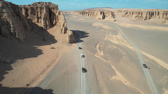 航拍新疆哈密大海道无人区荒漠上行驶的汽车