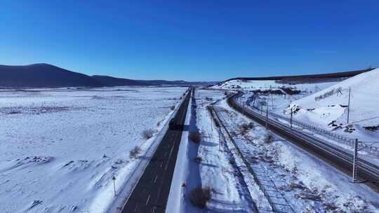 雪后公路铁路并行的辽阔景象