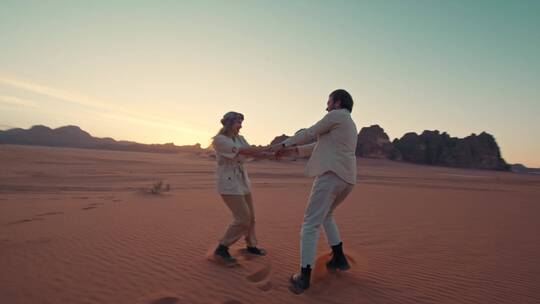 在沙漠上跳舞的情侣