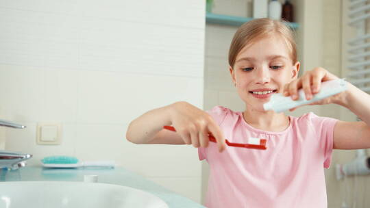 特写女孩把牙膏放在牙刷上视频素材模板下载